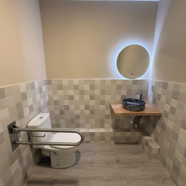 Rehabilitación de baño con espejo para una vivienda accesible